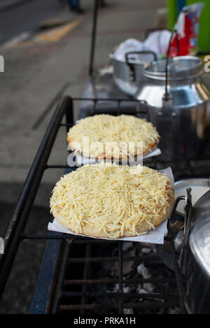 Cheese topped Arepas (traditional colombian food) in the making. Food truck on the street of Salento, Colombia. Sep 2018 Stock Photo