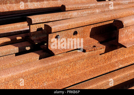 Backgrounds and textures: group of rusty steel rails, stacked in a pile outdoors, industrial abstract Stock Photo