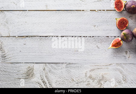 A few figs freely lying on old wooden table. Stock Photo