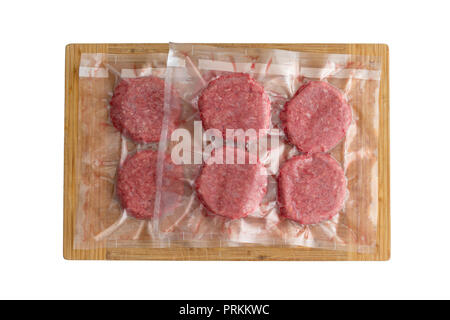 Isolated fresh beef burger patties in a vacuum pack ready to be frozen for sous-vide cuisine viewed from above on wood Stock Photo