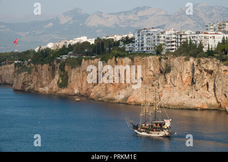 Wooden tourist boat on sightseeing trip along dramatic coastline in Antalya, Turkey Stock Photo