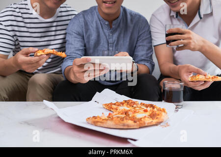 Positive joyful friends enjoying their pizza Stock Photo