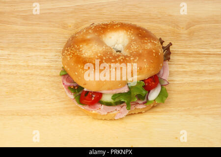 Ham salad bagel on a wooden chopping board Stock Photo