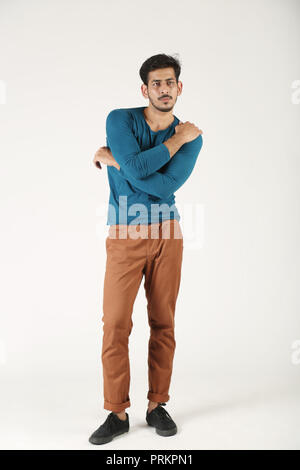 Indian boy is standing with cross hand on white background. Stock Photo