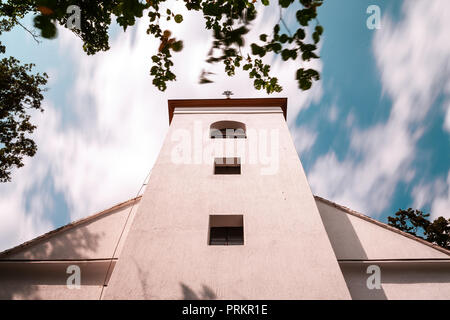 A simple white chapel from below with moving clouds. Long exposure shot. Stock Photo