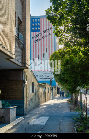 A Stars & Stripes flag runs down the side of a building, the stars a set of skulls, the stripes turning into bombs, across it burned the legend 'Down  Stock Photo
