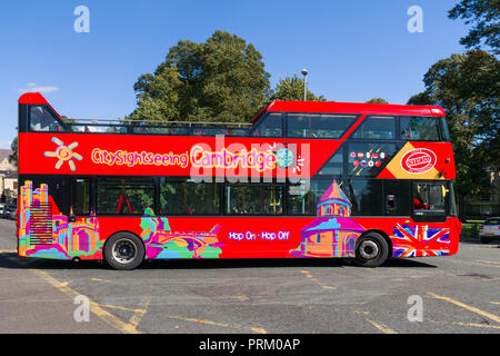 A red open top double decker city sightseeing bus driving on road, Cambridge, UK Stock Photo