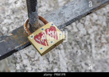 Padlock lovelock with You / Me, His and Hers hearts painted. Metaphor 'promises made'. Lock in place metaphor. Stock Photo