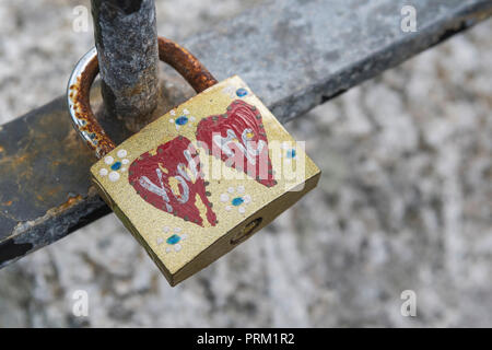 Padlock lovelock with You / Me, His and Hers hearts painted. Metaphor 'promises made'. Locked in place, lock in place metaphor. Stock Photo