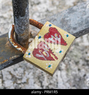 Padlock lovelock with You / Me, His and Hers hearts painted. Metaphor 'promises made'. Lock in place metaphor. Stock Photo