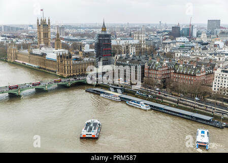 Overview of The Palace of Westminster and the Thames river with boats sailing and moored on the River Thames in the city of London, England, United Ki Stock Photo