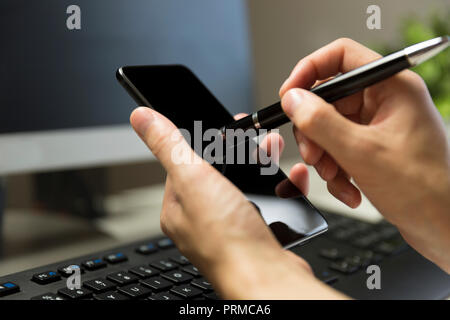 Women's hands touches phone screen with pen for touchscreen. Stock Photo