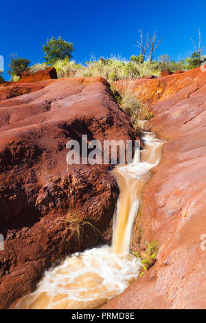 A little river running through an area of intensely red dirt near Waimea Canyon in Kauai, Hawaii. Stock Photo
