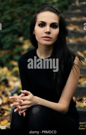 brunette girl on the stairs. it is autumn in the street Stock Photo