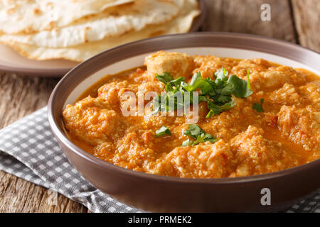 Chicken changezi cooked in a sauce with yogurt, nuts, spices, tomatoes served with flat bread close-up on the table. horizontal Stock Photo