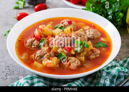 Hot stew tomato soup with meatballs and vegetables closeup in a bowl on the table. Albondigas soup, spanish and mexican food. Stock Photo