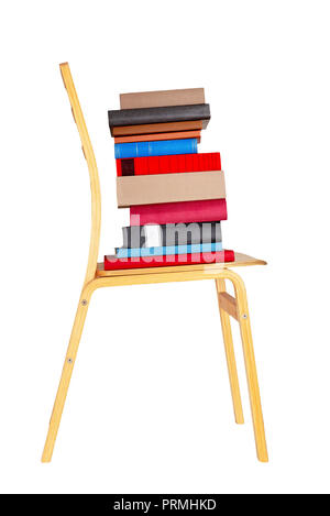 Colorful books on wooden chair isolated on white background. Stock Photo