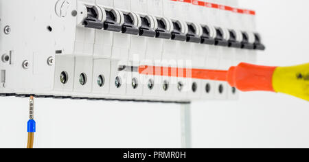 electric machines, switches, isolated on white background, close-up, connect marker cable to a device with a red screwdriver Stock Photo