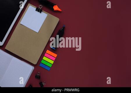 Study stuff. Education background. Stationery. Aspects of education. Tablet, papers, markers, stickers, clips and opened notebook on the table. Stock Photo