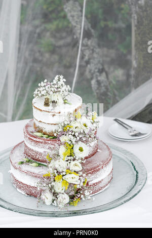 romantic rustic pastel floral design wedding cake on table outdoors Stock Photo