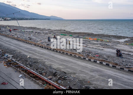 Palu, Indonesia. 4th Oct 2018. Residents seen crossing the damaged Cumi-cumi road after the earthquake and tsunami. A deadly earthquake measuring 7.7 magnitude and the tsunami wave caused by it has destroyed the city of Palu and much of the area in Central Sulawesi. According to the officials, death toll from devastating quake and tsunami rises to 1,347, around 800 people in hospitals are seriously injured and some 62,000 people have been displaced in 24 camps around the region. Credit: SOPA Images Limited/Alamy Live News Stock Photo