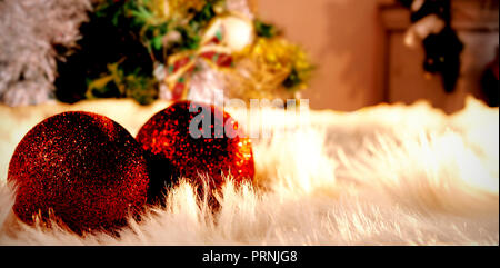 Composite image of two red christmas balls on a white fur Stock Photo