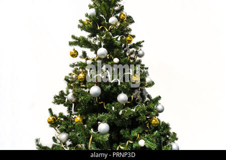 decorated Christmas tree isolated on white background. Christmas tree decorated with yellow and white balls and tinsel. Stock Photo