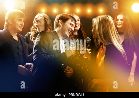 Happy friends at karaoke party night club Stock Photo