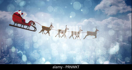 Composite image of side view of santa claus riding on sleigh during christmas Stock Photo