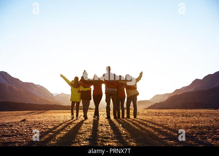 Group of friends against sunset mountains Stock Photo