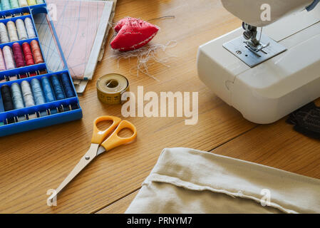 Home sewing with sewing machine and accessories on table Stock Photo