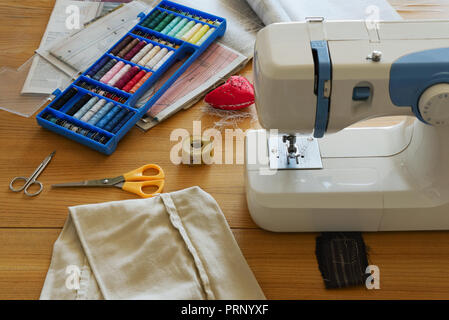 Sewing machine and sewing accessories on table Stock Photo