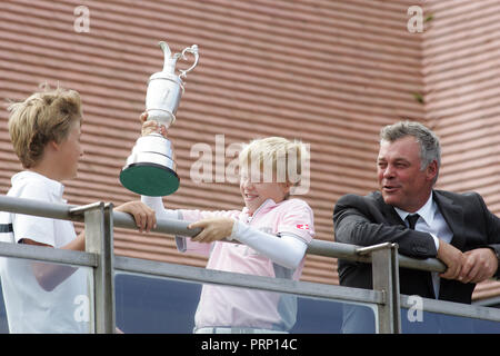 Northern Irish golfer Darren Clarke smiles with his sons Tyrone and Conor as they share holding the Claret Jug at Royal Portrush Golf Club in Portrush,  County Antrim, Northern Ireland, Tuesday July 19th, 2011. Photo/Paul McErlane Stock Photo