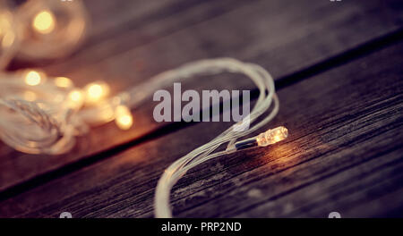 Christmas garland lights from LED bulbs on the wooden background Stock Photo