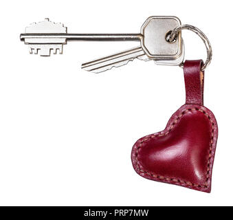 bunch of door keys on handmade burgundy leather heart shaped key fob cutout on white background Stock Photo