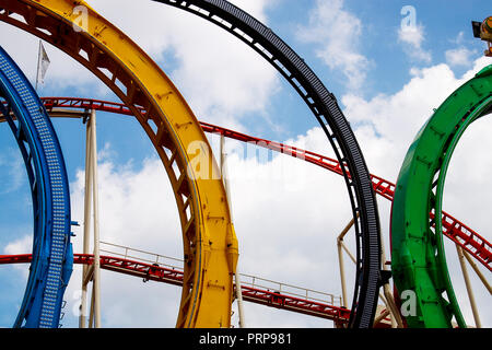 Colorful roller coaster tracks in blue, yellow, black and green in the famous Prater fun fair in Vienna, Austria, Central Europe Stock Photo