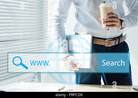cropped view of seo developer holding laptop and coffee to go, with website search bar Stock Photo