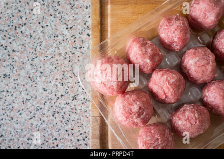 Pork meat balls. Package over cutting board Stock Photo