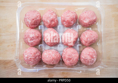 Pork meat balls. Package over cutting board Stock Photo