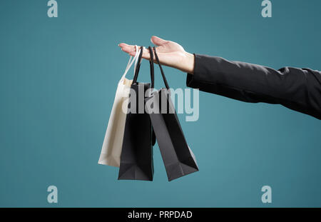 Close up of man hand with shopping bags , isolated on light blue background . Stock Photo