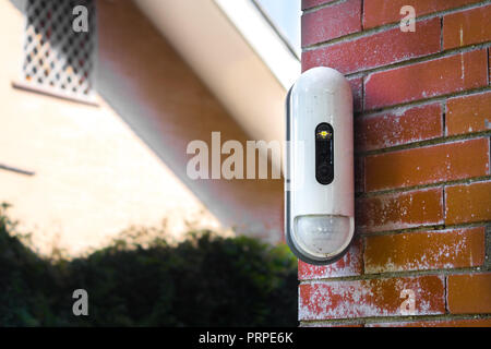 Surveillance Camera With Movement Detector on Red Brick House Stock Photo