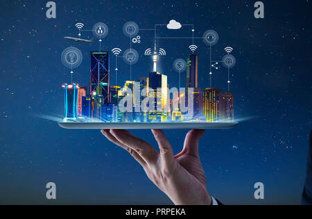 Waiter hand holding an empty digital tablet with Smart city with smart services and icons, internet of things, networks and augmented reality concept 