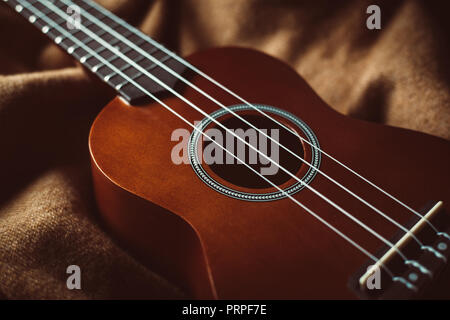 closeup photo of a ukulele against a brown background Stock Photo