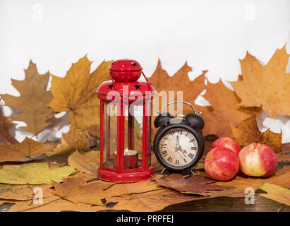 Red lantern lamp with candle and apples on red background. Stock Photo