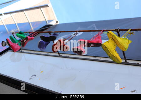 Shot of shoes hanging from the side of a building in Toronto. Places where you see shoes thrown on a wire indicate places where you can buy drugs. Stock Photo