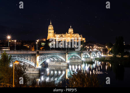 Night view of Salamanca Old and New Cathedrals from Enrique Esteban Bridge over Tormes River, Community of Castile and León, Spain.  Declared a UNESCO Stock Photo