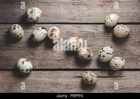 top view of fresh raw healthy quail eggs on rustic wooden table Stock Photo