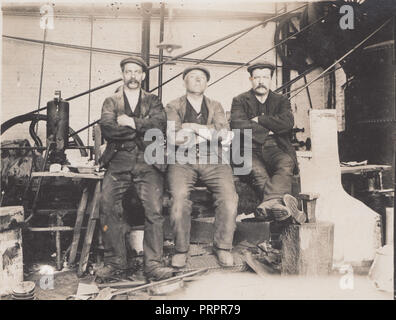 * Vintage Photograph Showing Three Workers inside a Factory or Workshop Stock Photo