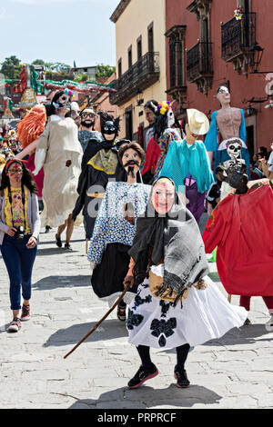 Giant paper-mache puppets called Mojigangas participate in the annual parade celebrating the cities patron saint during the Feast of Saint Michael September 30, 2018 in San Miguel de Allende, Mexico. The festival is a four-day long event with processions, parades and a late night fireworks battle. Stock Photo