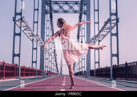 Beautiful graceful young woman doing elegant movements Stock Photo